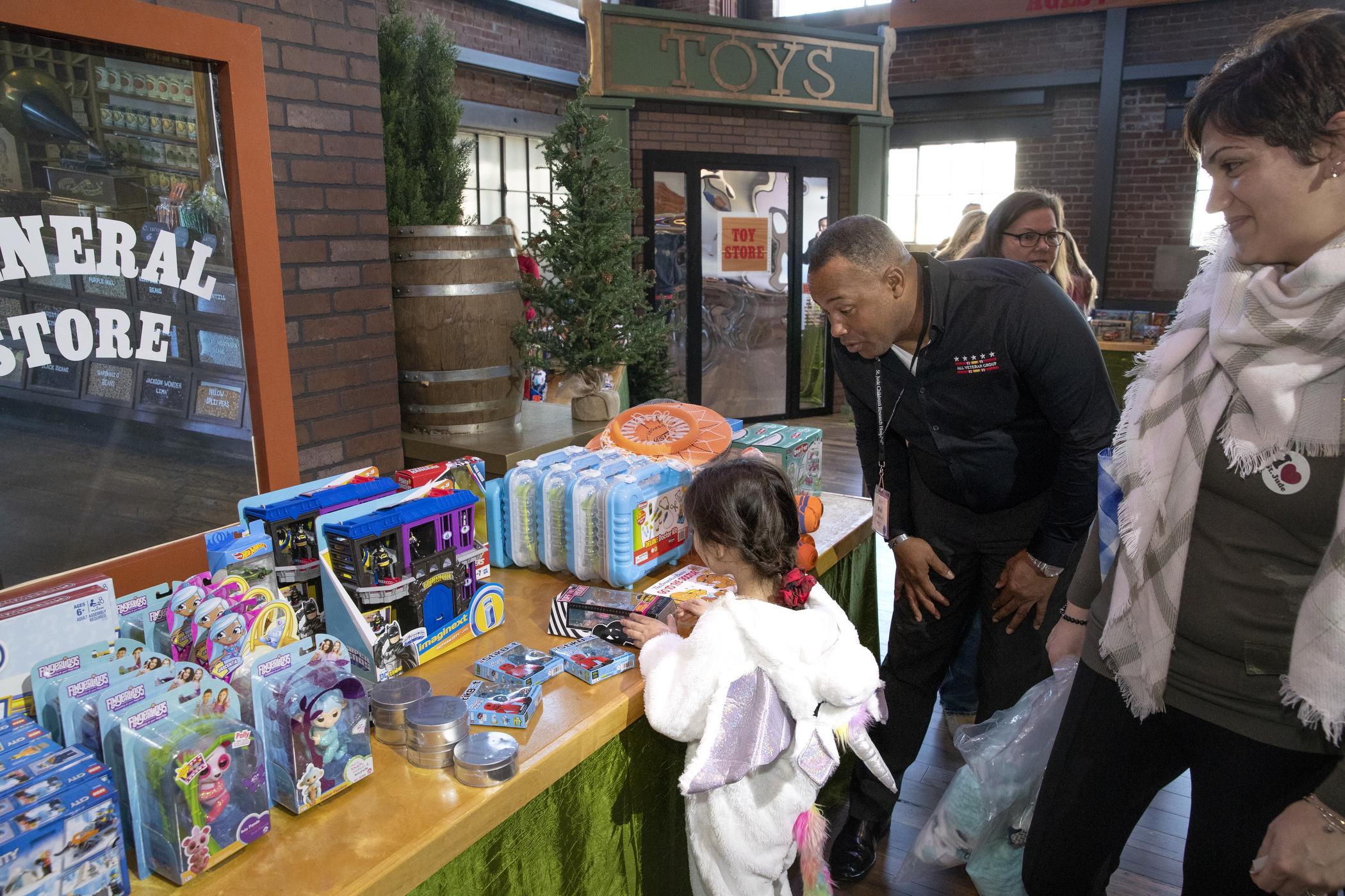 Child picks out gift from display table during Window World Day celebration at St. Jude