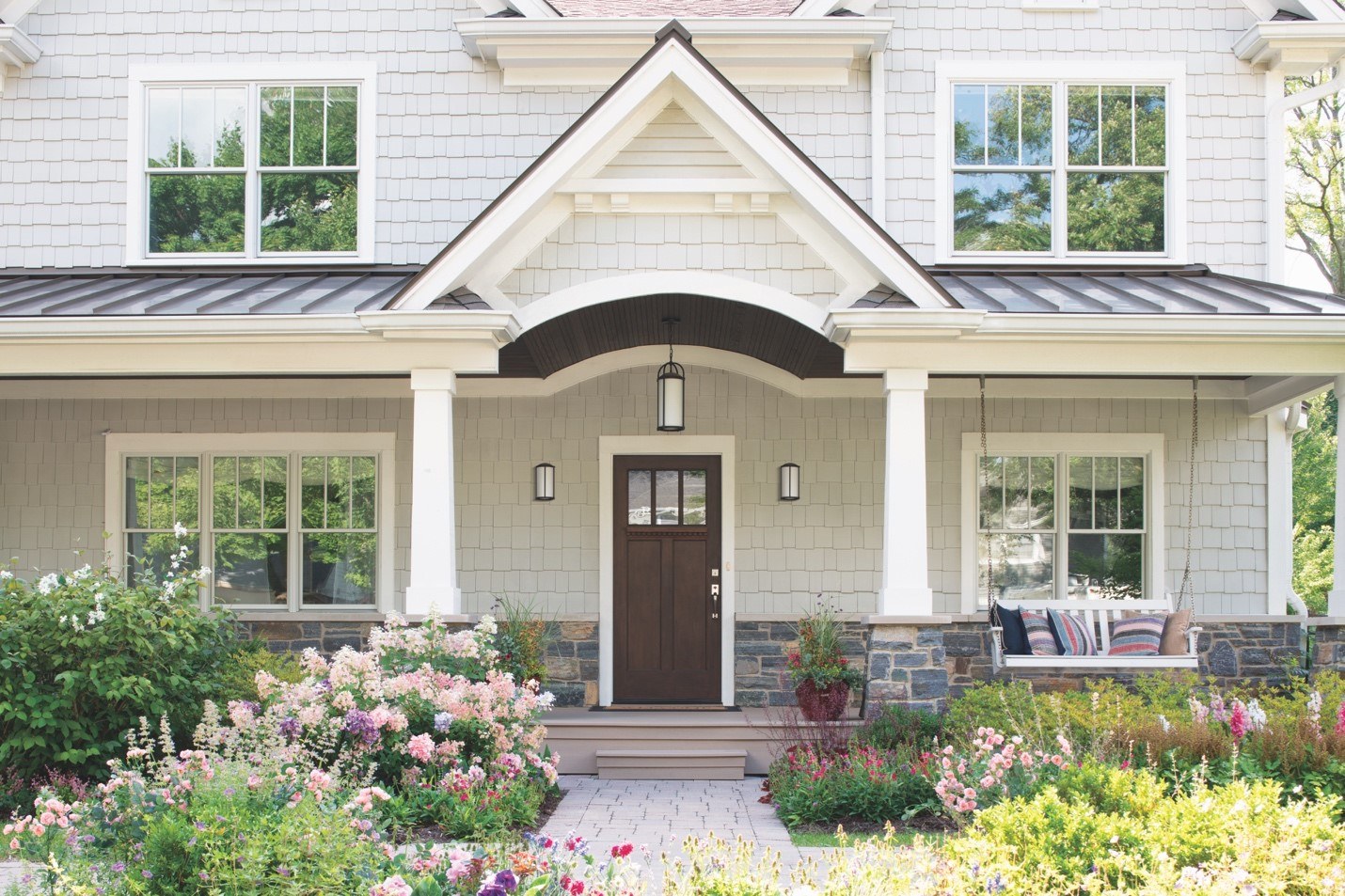 A front porch with a swing and energy-efficient entry door