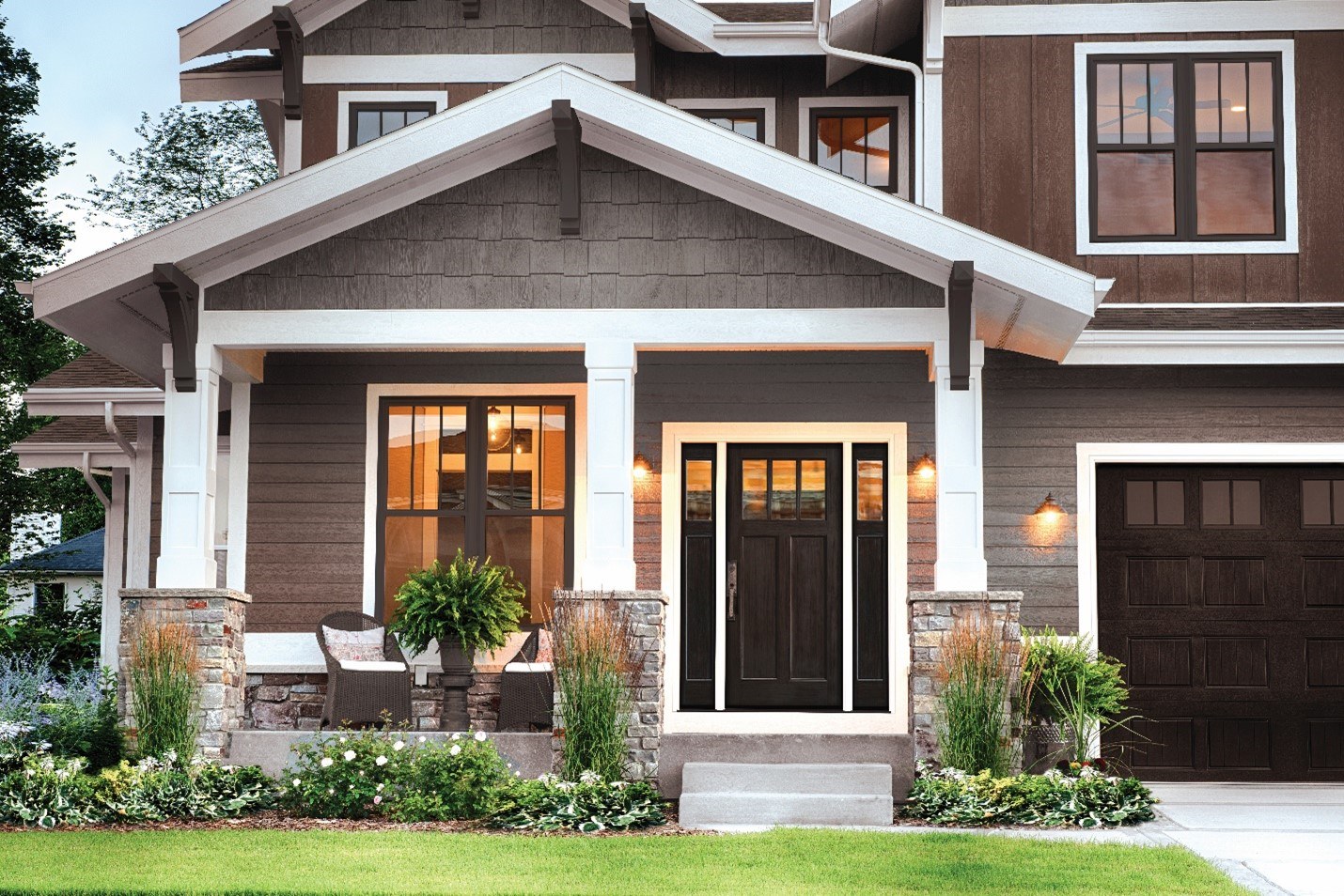 A modern-style house with a front door, front porch, and greenery