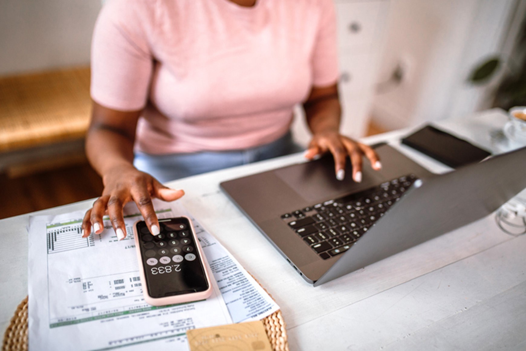 A person using a calculator and a computer