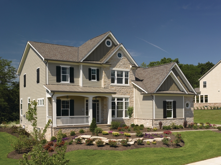 An attractive home with two types of roof materials: asphalt shingles and corrugated metal.