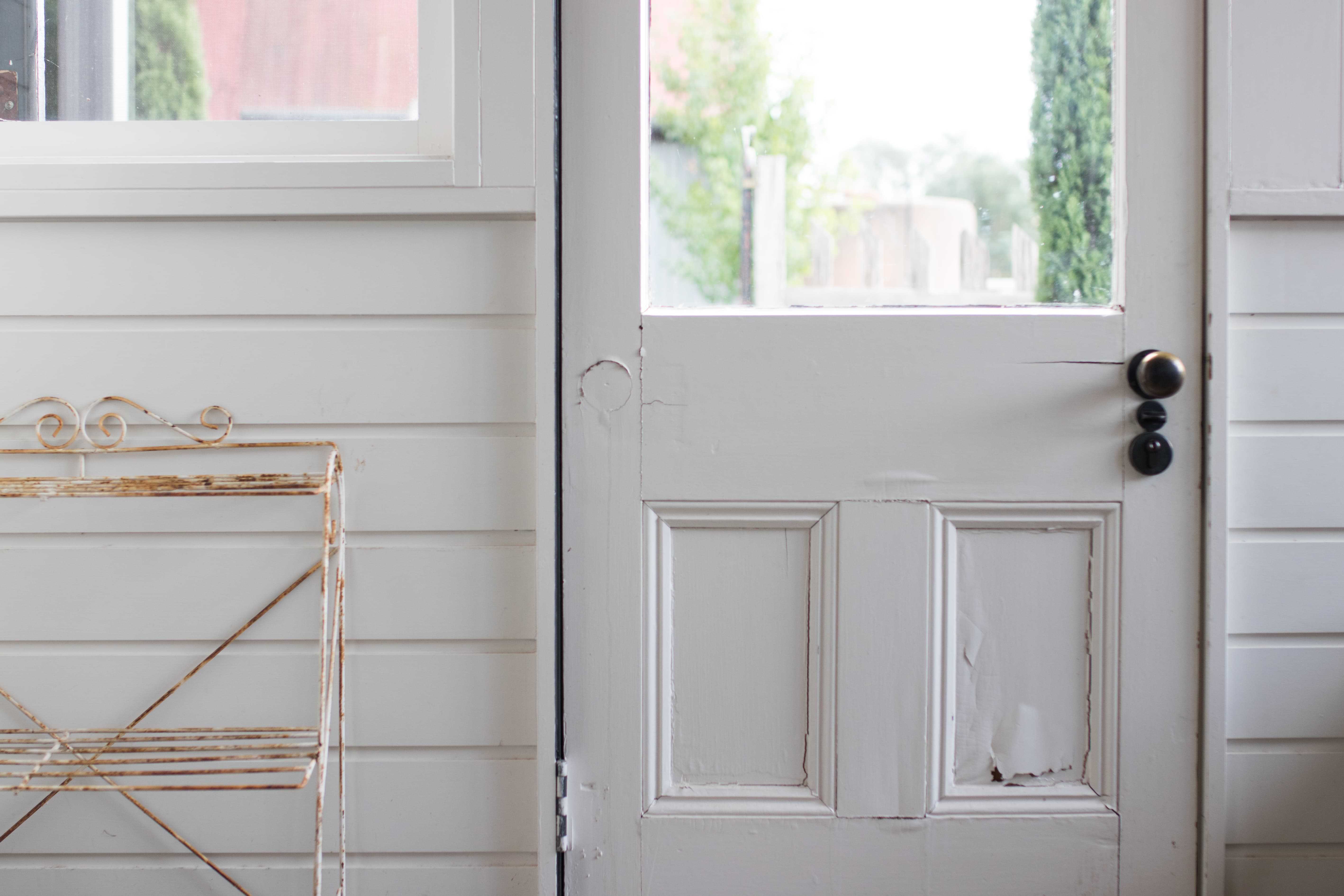 white front door with cracks in it that needs replacing