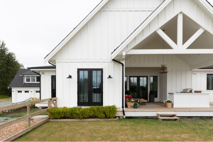 Front view of a farmhouse-style home with a large front porch Front view of a farmhouse-style home with a large front porch