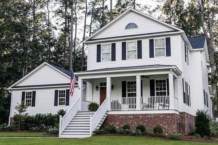 Front view of a large white farmhouse-style home