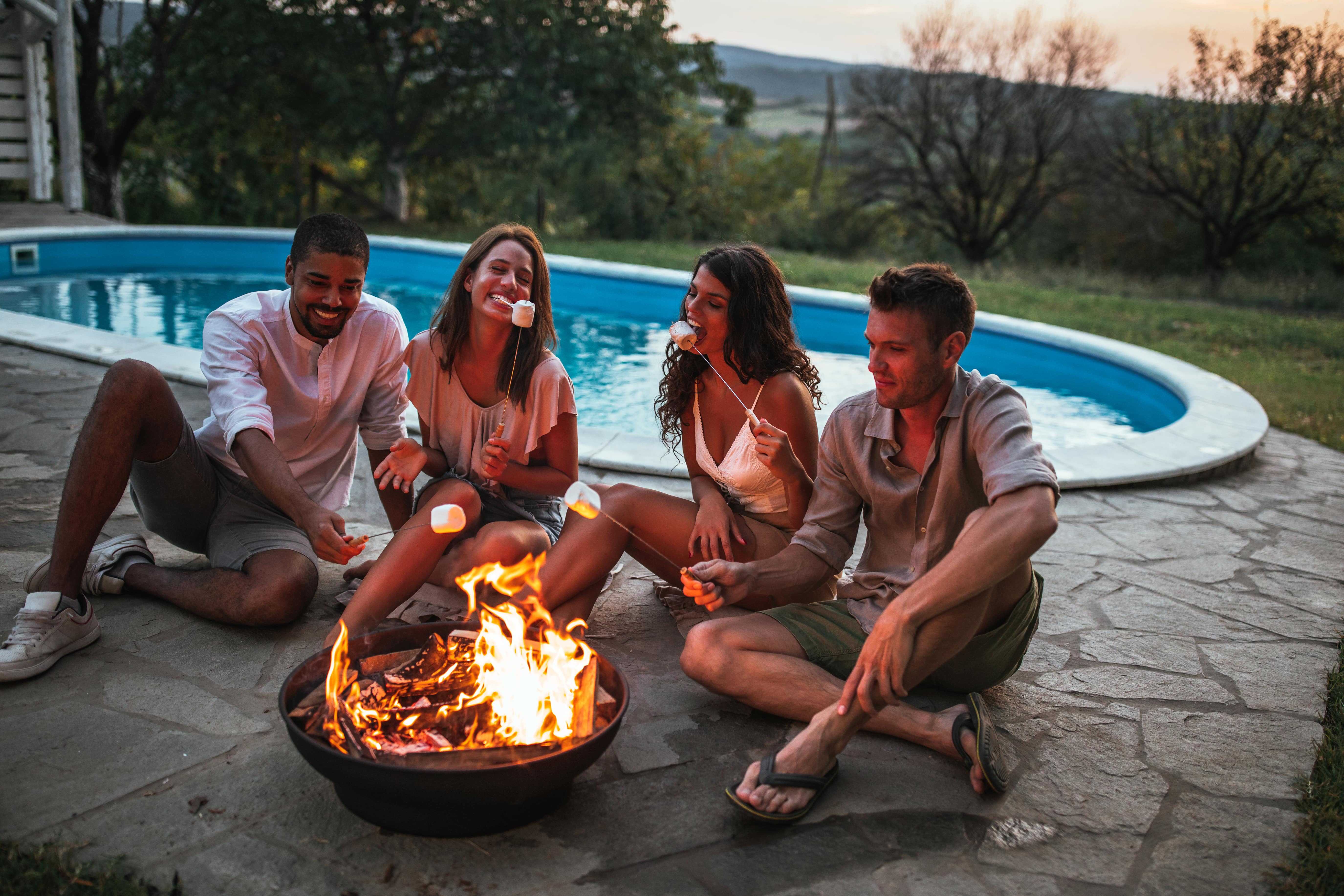 Two couples making smores in a fire pit