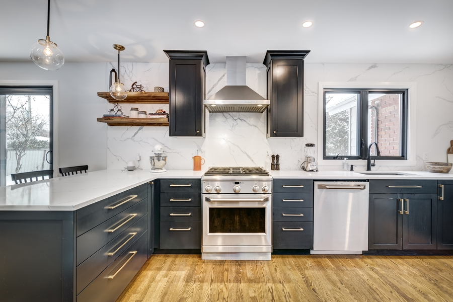 a kitchen with white countertops and black cabinets