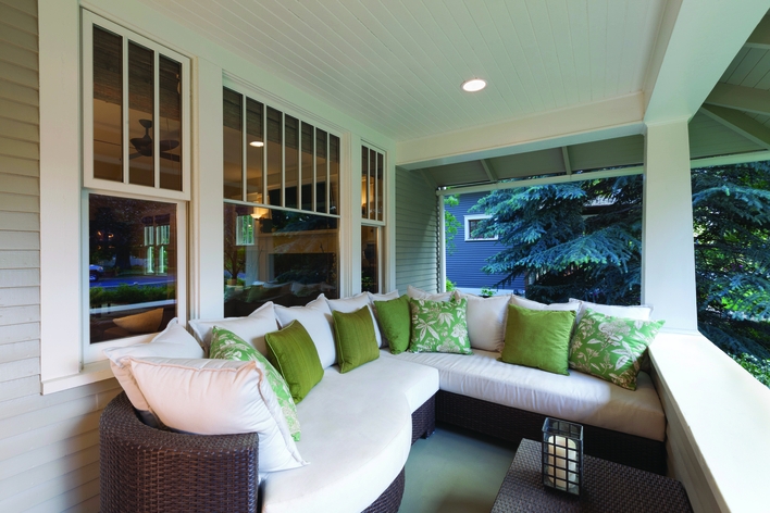 A front porch sitting area with summery throw pillows