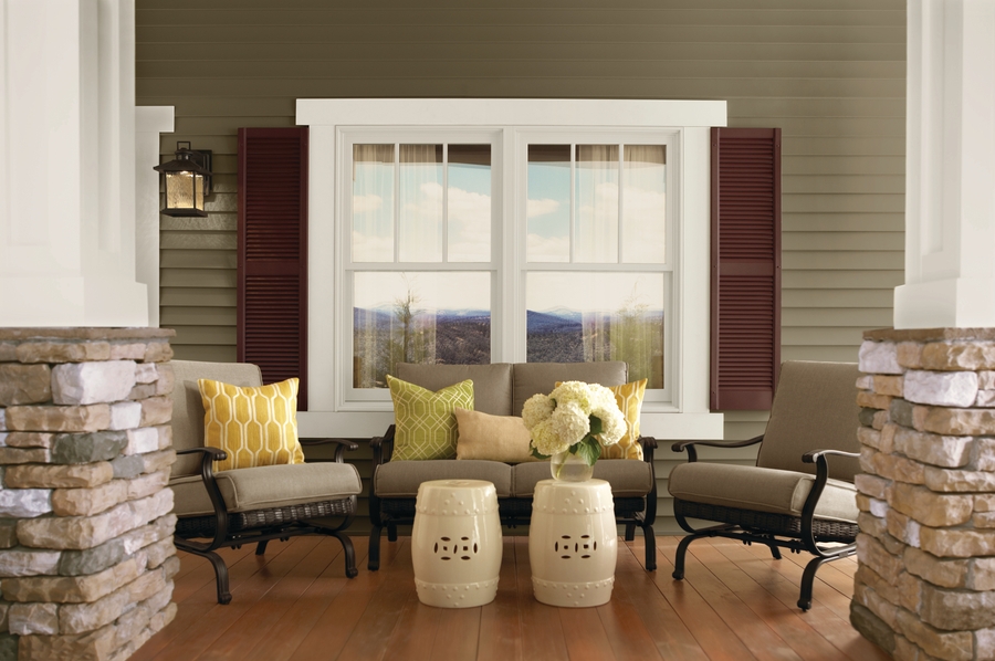 Outdoor seating in front of double-hung windows on a porch