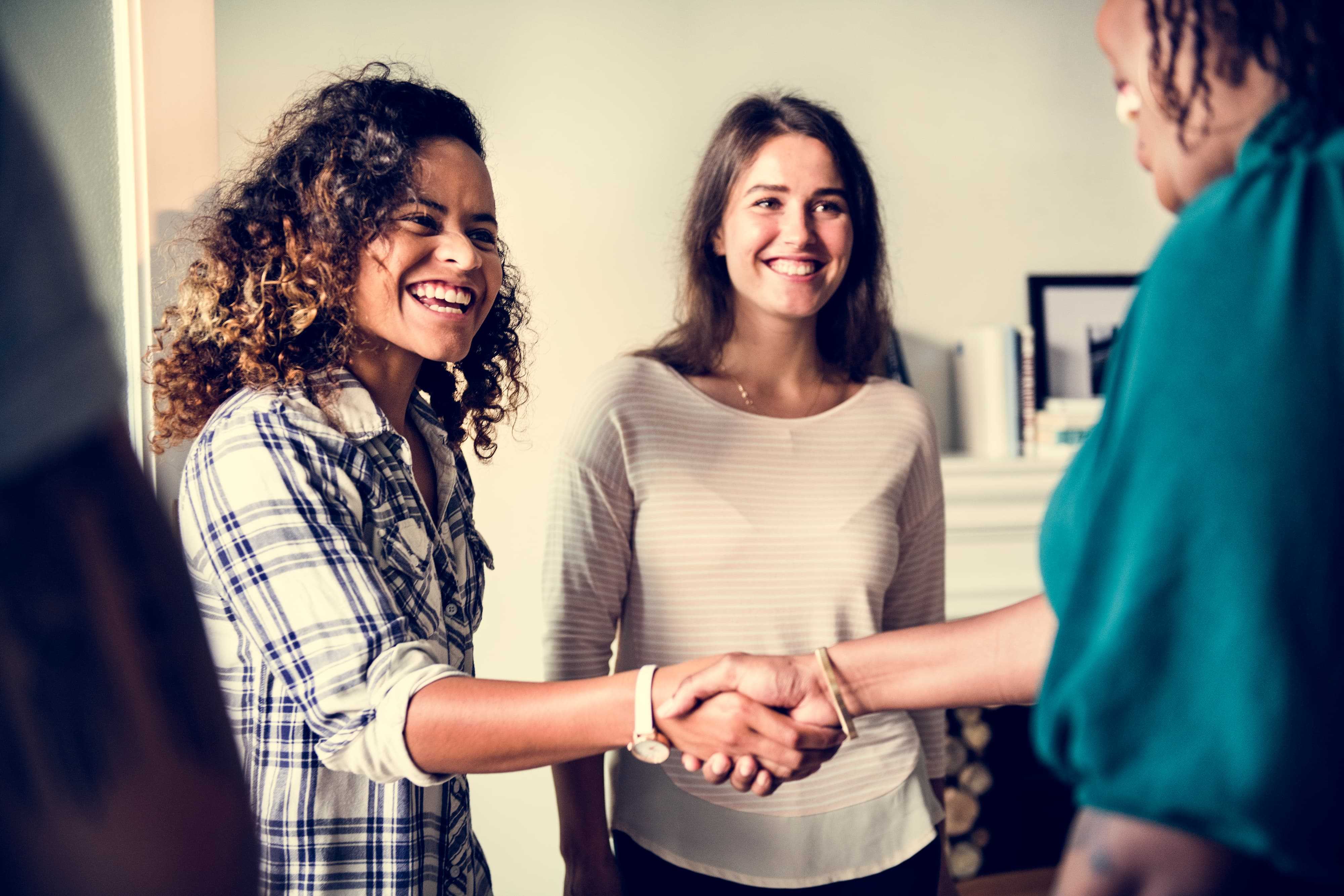 A first time homeowner shaking hands with a new neighbor.