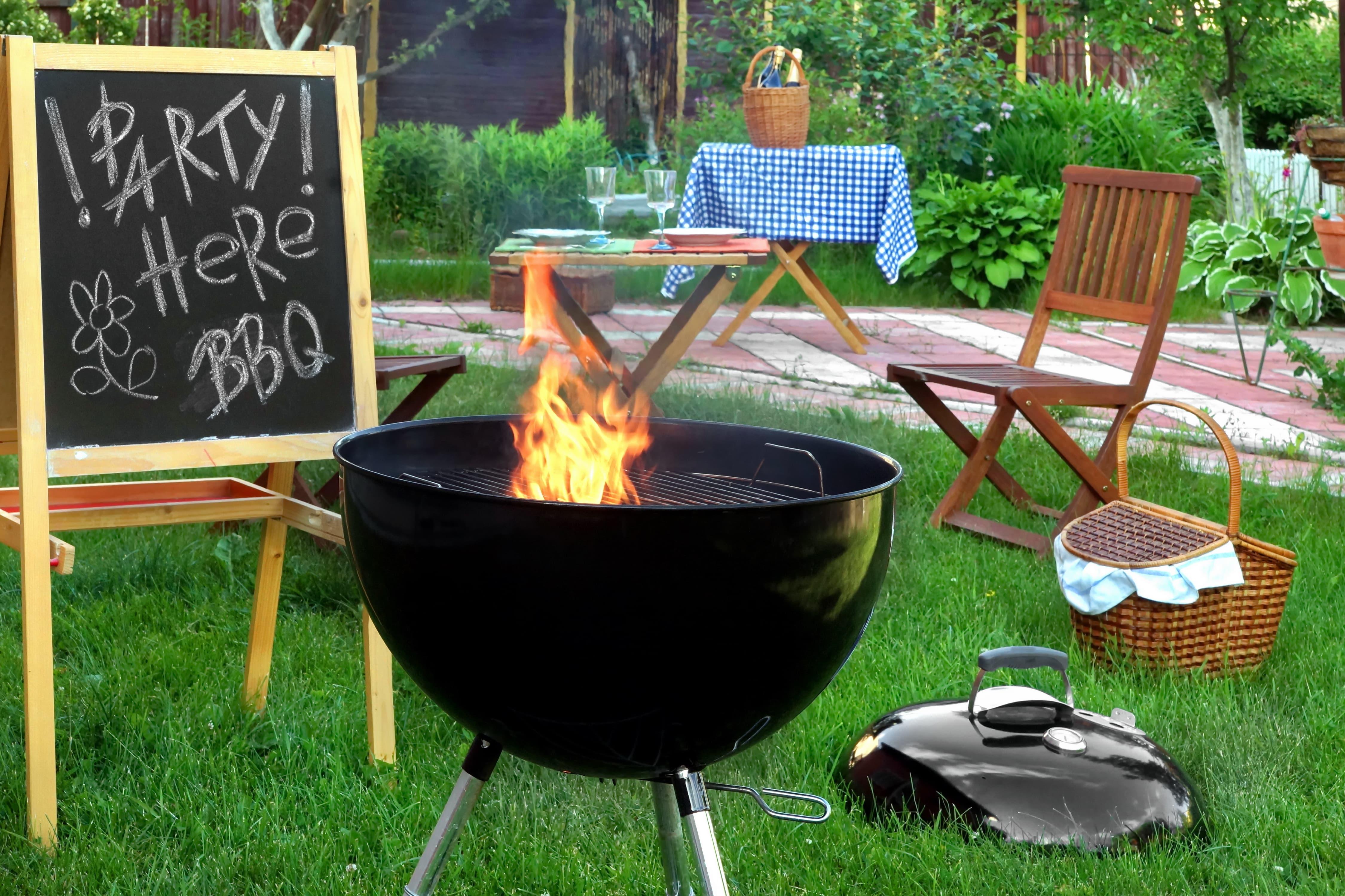 Charcoal grill and sign indicating a backyard BBQ party