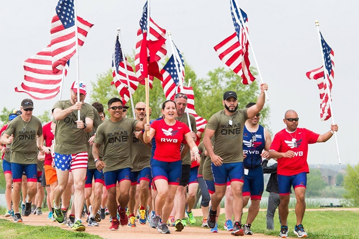 Smiling people carry the American flag for a good cause