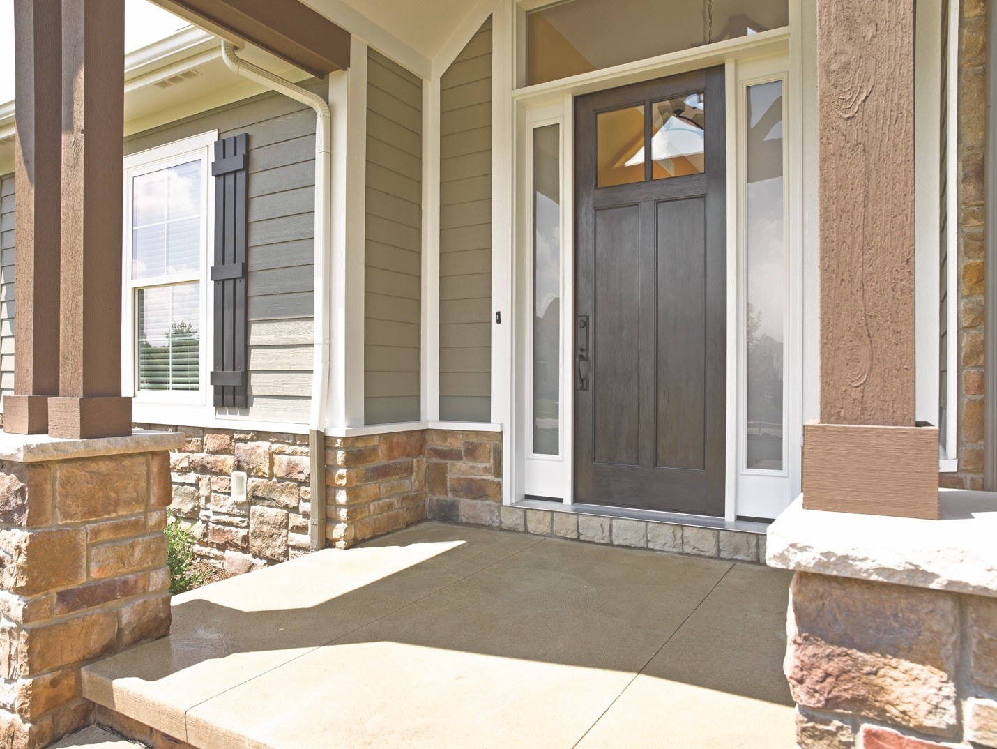 The entrance to a home with stacked-stone foundation details and an energy-efficient front door