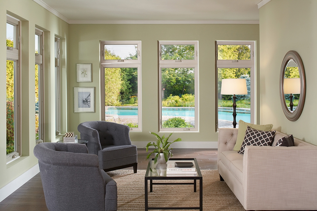 Sitting room with multiple windows facing a swimming pool outside during hot weather