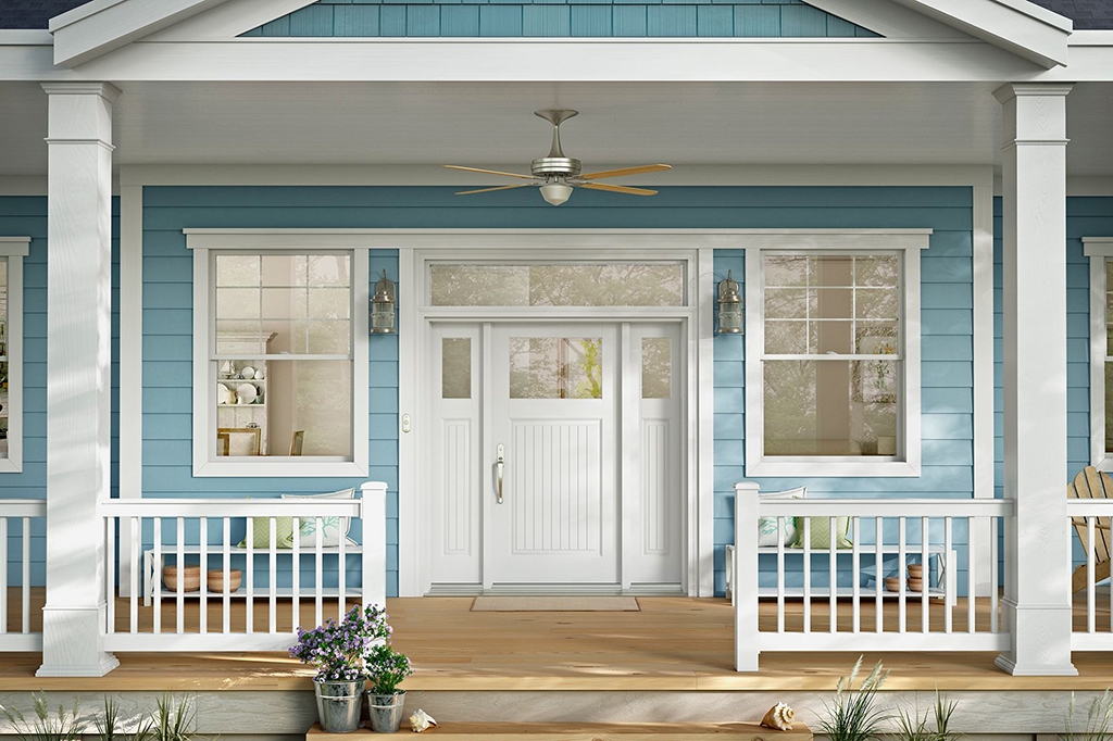 Front porch of a house in summer with blue siding and white windows and door