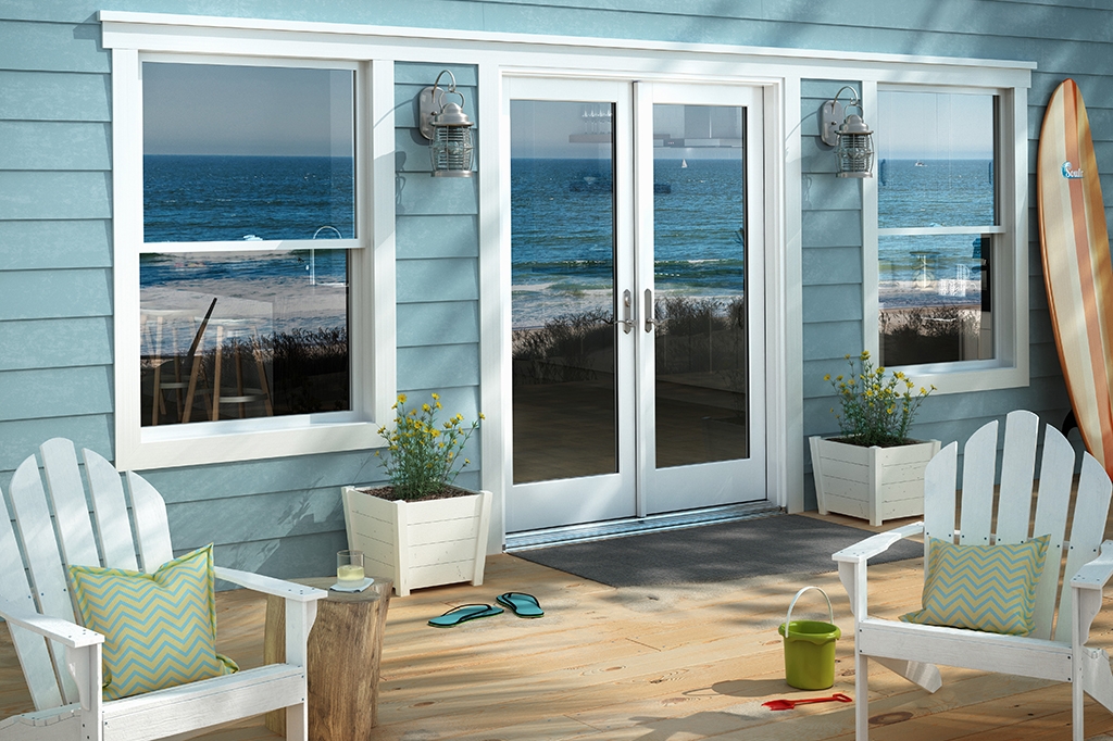 Back porch or patio of home with blue siding and white trim on doors and windows