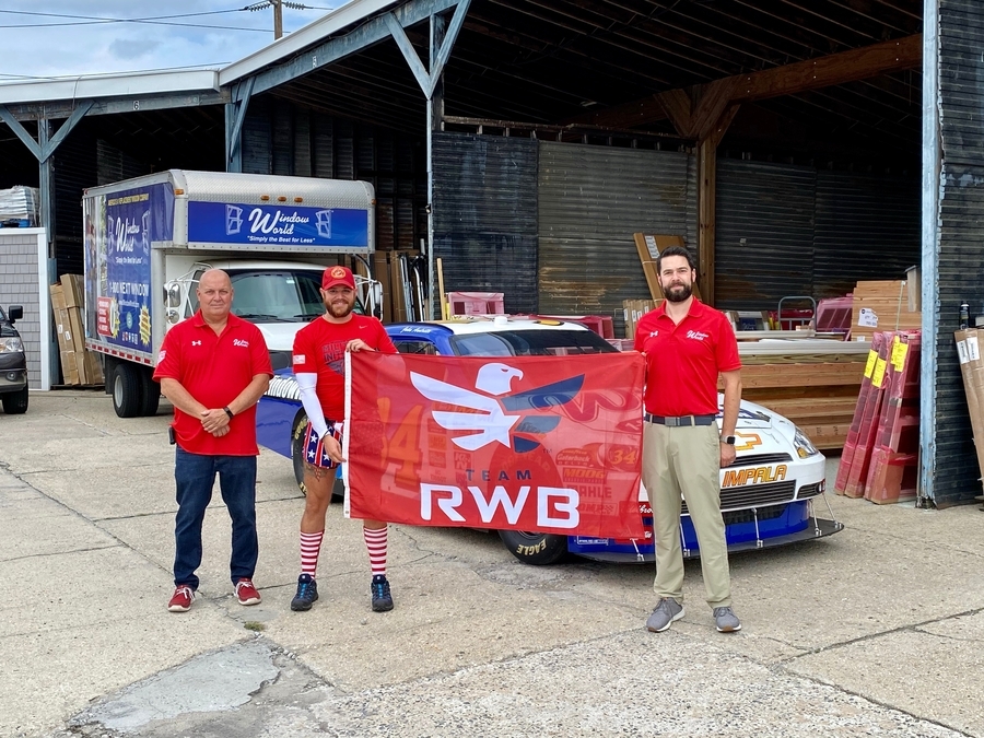 Group holding a Team Red, White & Blue flag in support of veterans.