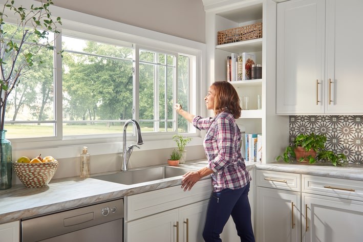 A woman opening kitchen window A woman opening kitchen window