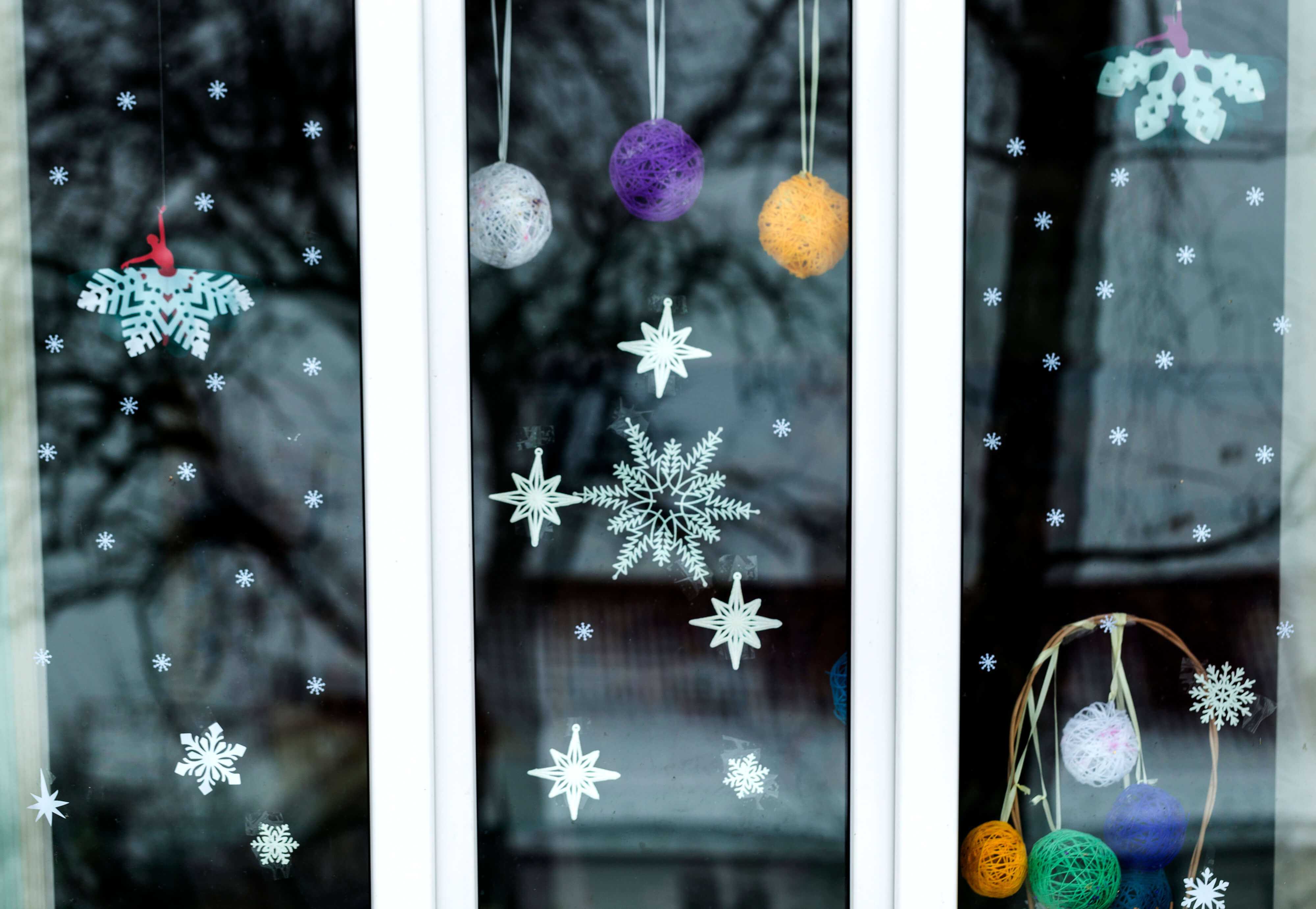 White kitchen garden window decorated with snowflakes 