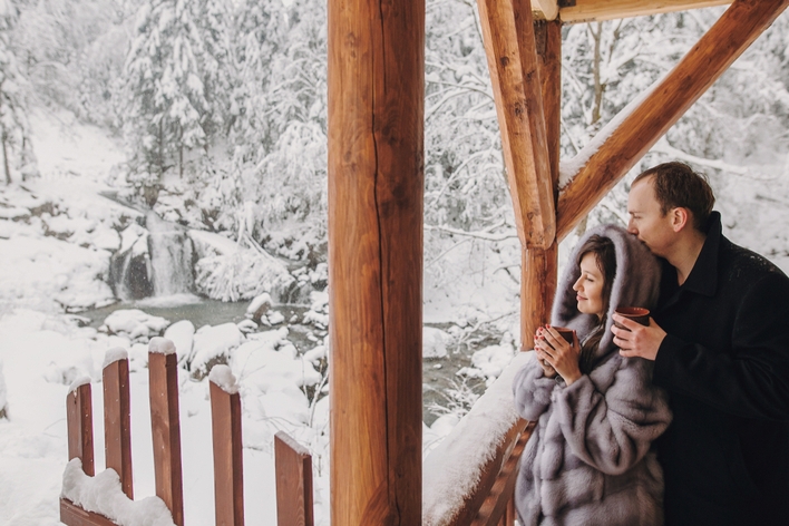 Couple watches snow together from porch