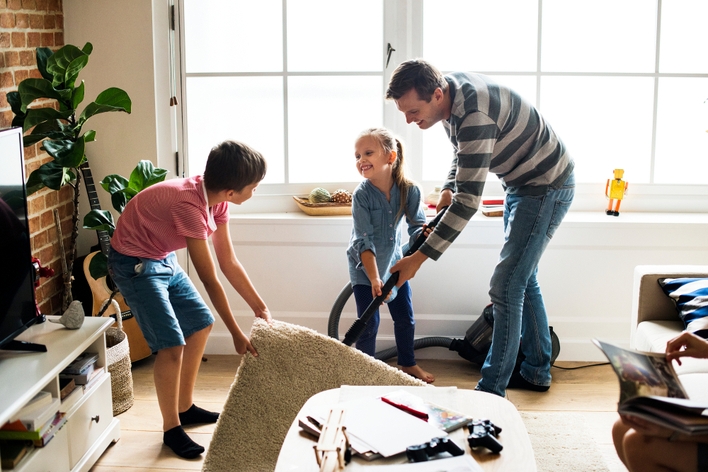 Dad and son cleaning living room together