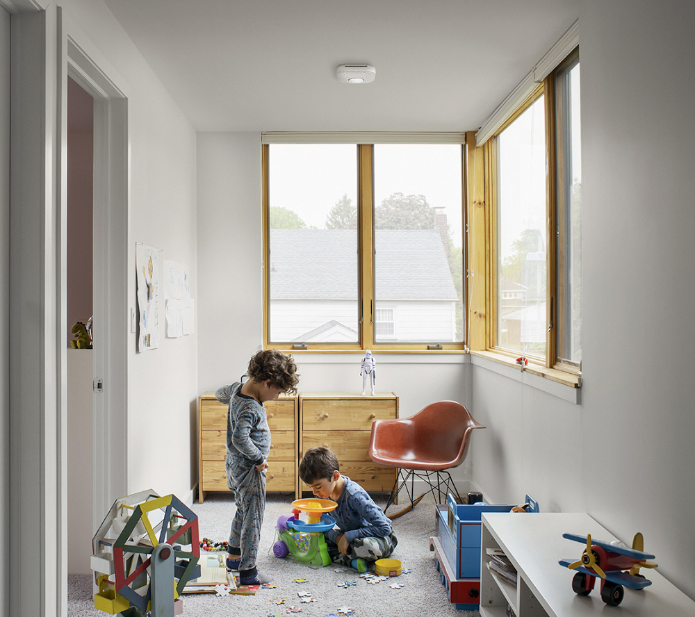 Kids playing in room with smart detector on ceiling