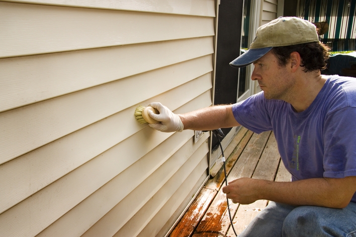 Man cleaning vinyl siding