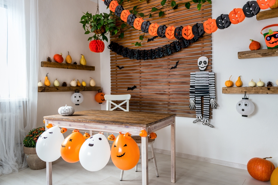 A room with a small brown wooden table and various Halloween décor A room with a small brown wooden table and various Halloween décor