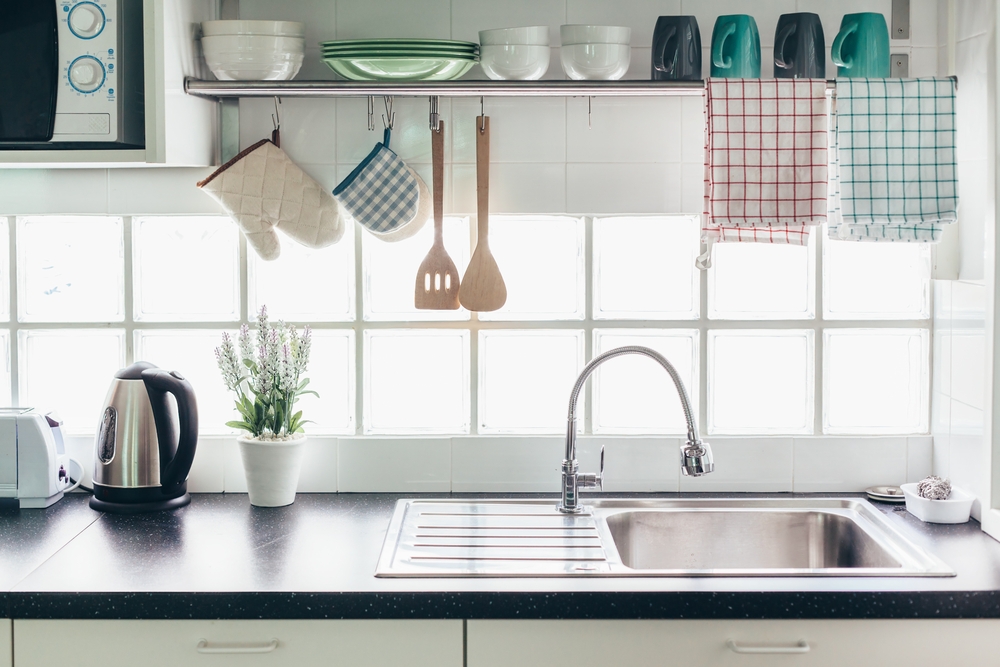 Cutlery and dishes stacked neatly above a kitchen sink