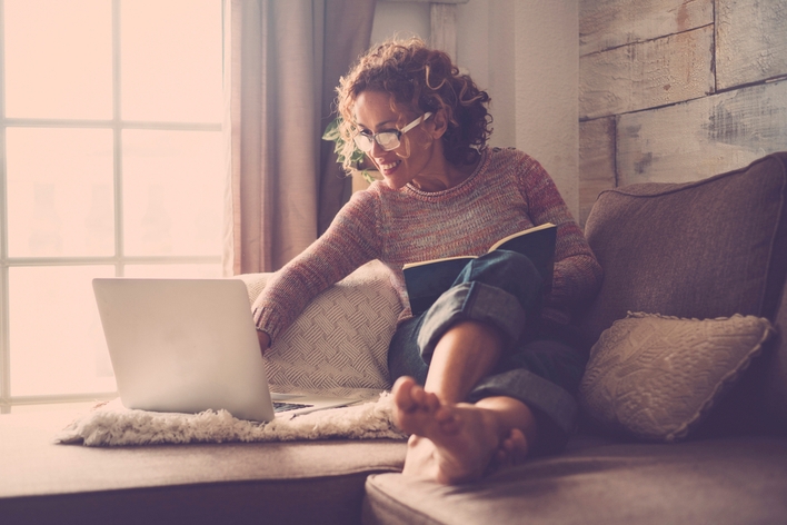 Woman reading on her computer by the light of a window