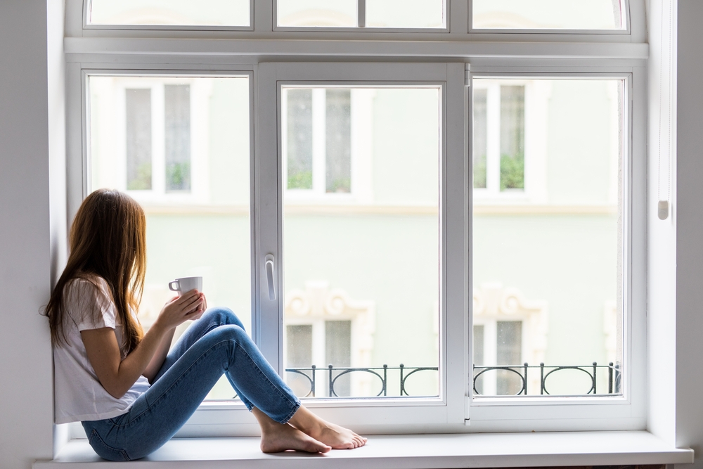 Woman sitting by window with coffee