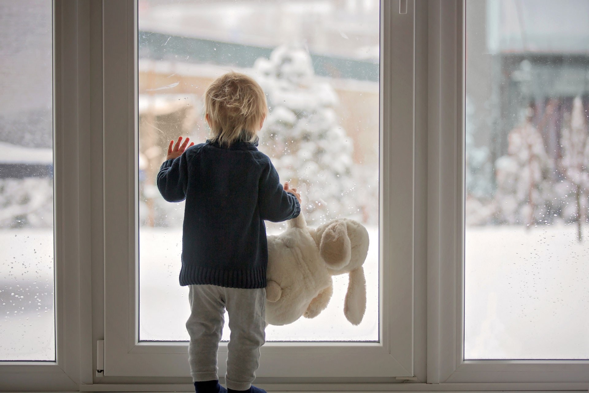 Young Boy Looking Out Window In Winter Too