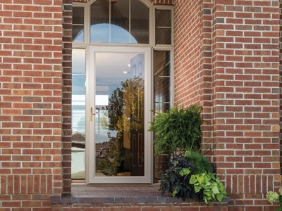 A full view storm door on a brick building.