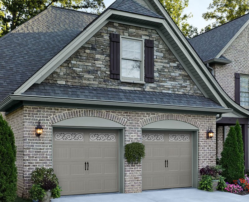 A brick home with a pair of Amarr Hillcrest replacement garage doors.