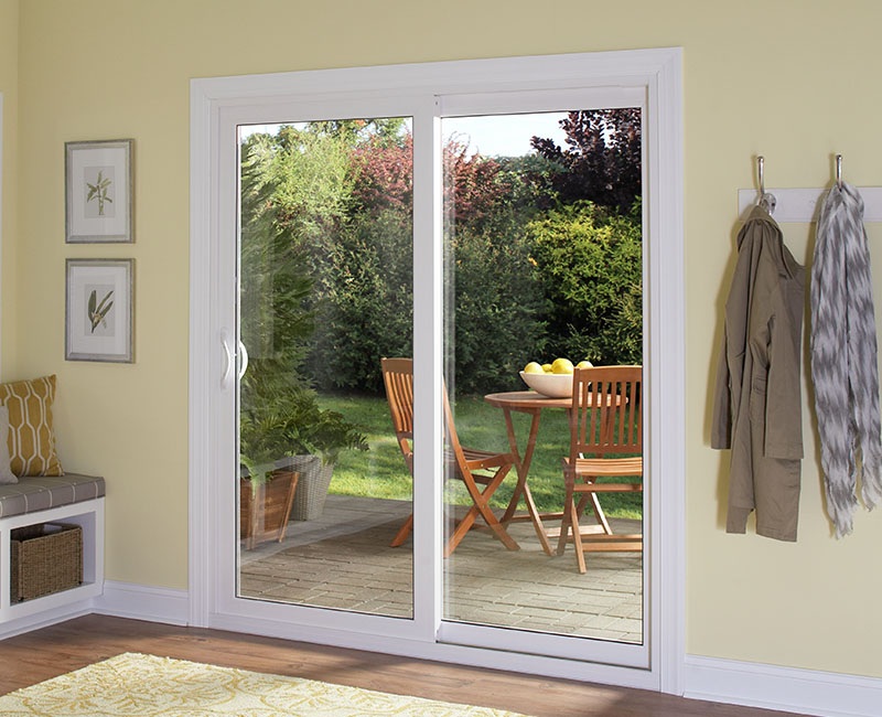 White sliding patio door looking onto a deck and backyard.